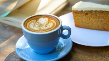 A picture of a cup of coffee and a slice of cake