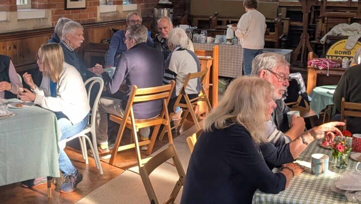 A picture of people enjoying cake and coffee at a Wiggaton church fundraiser for MacMillan Cancer Suppport
